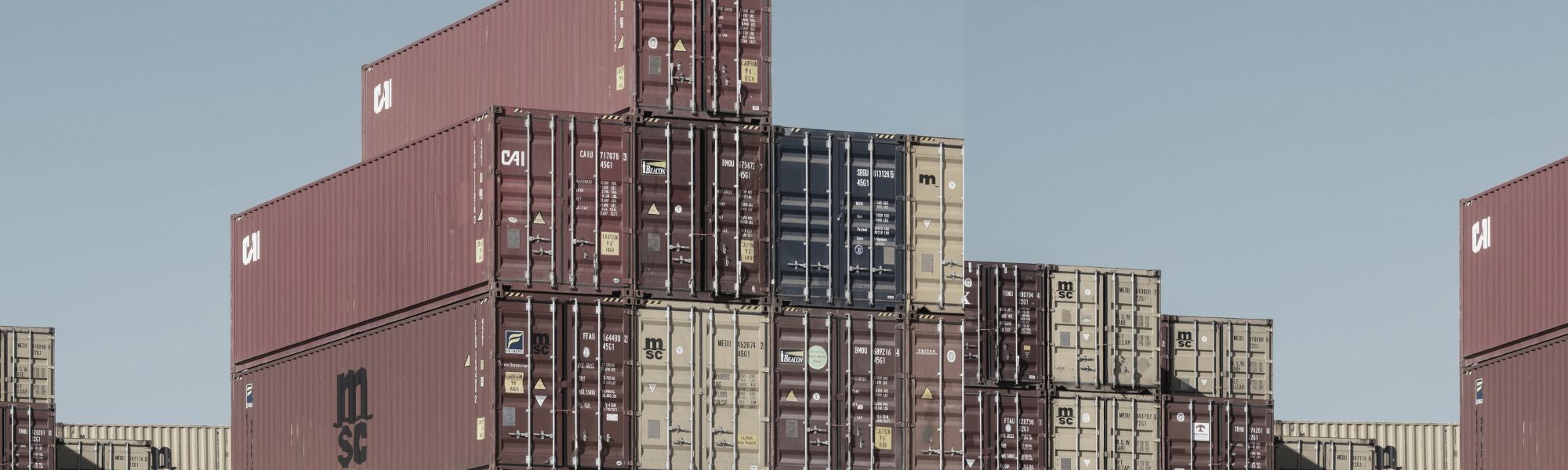 Stacked international shipping containers representing global risk intelligence